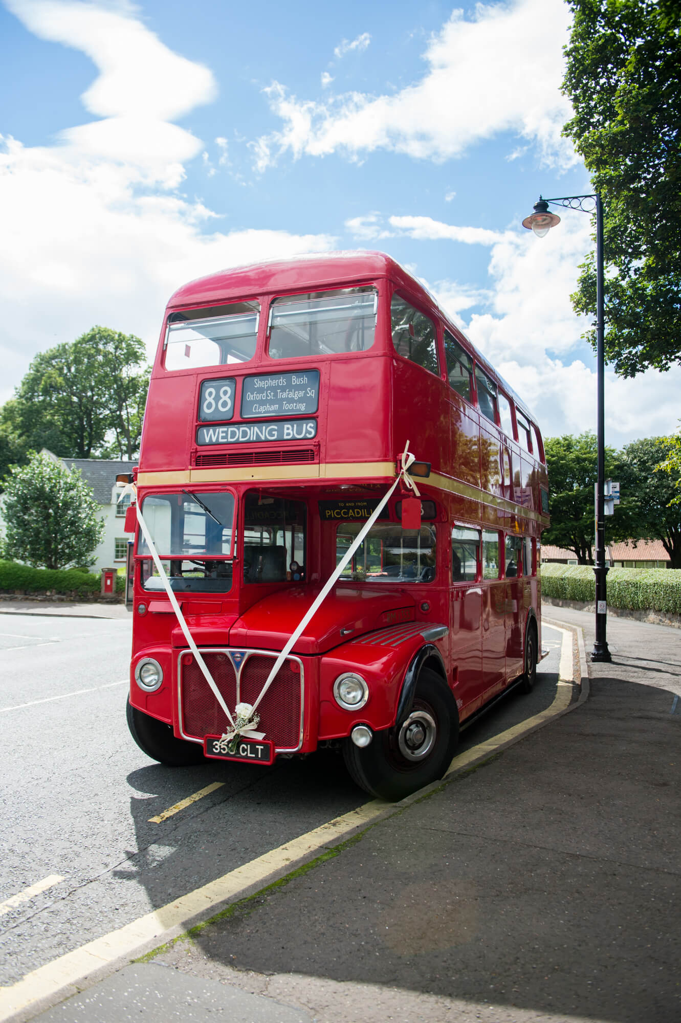 A vintage red route master with a ribbon tied on